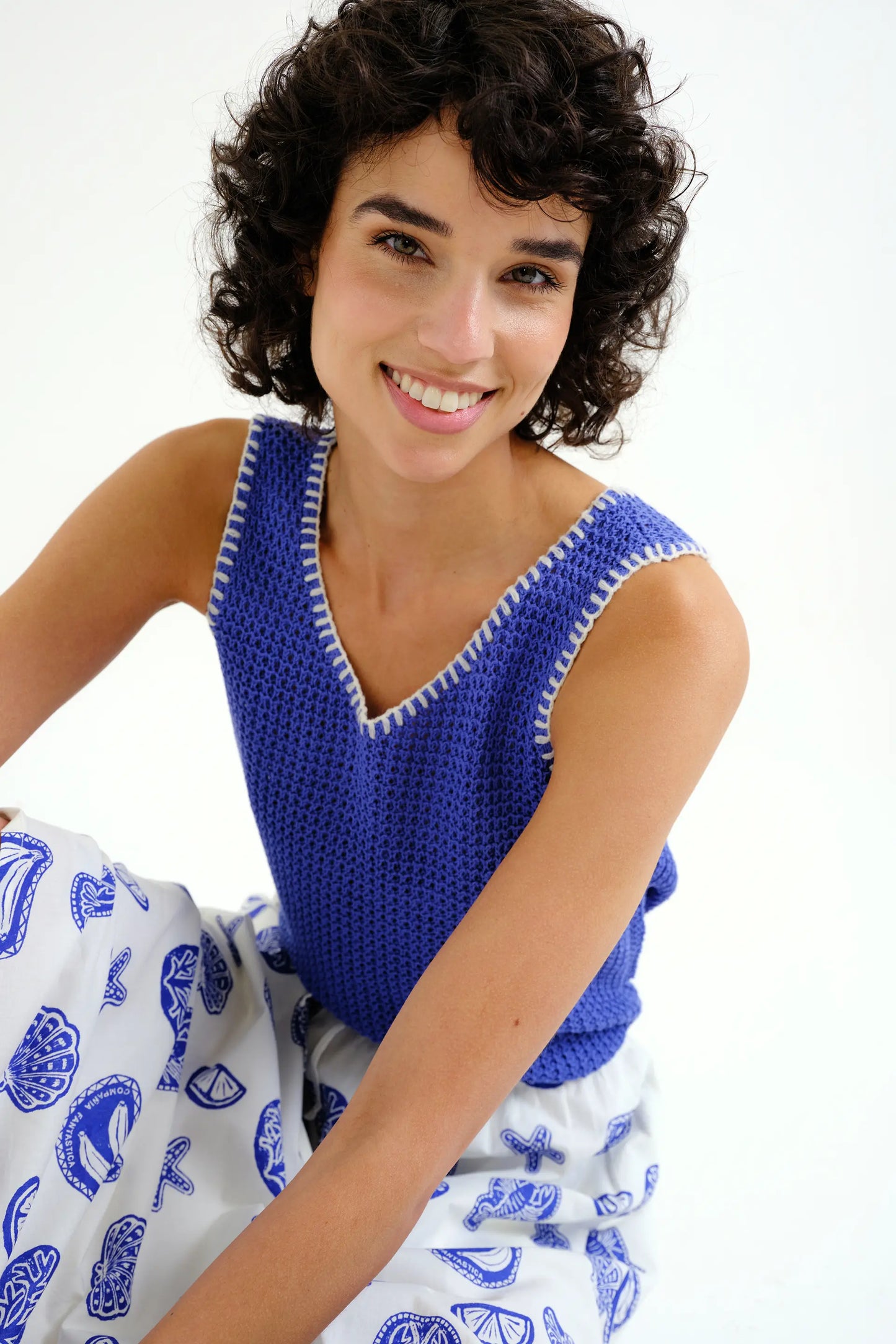 Top in maglia traforata blu con dettagli ricamati bianchi