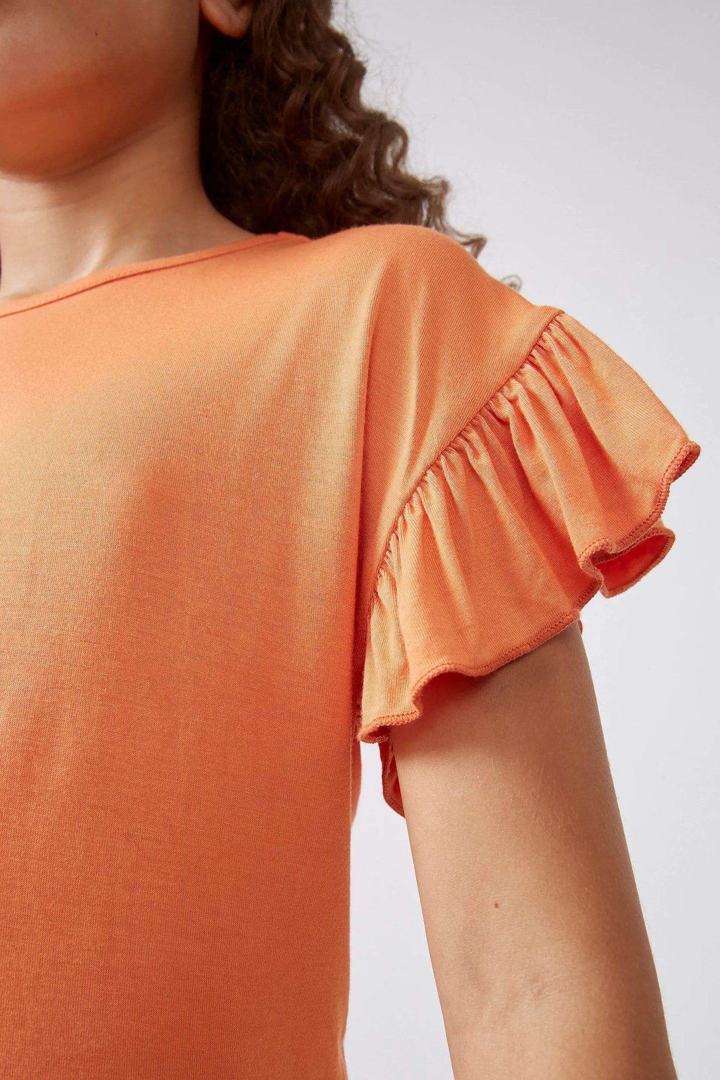 Top arancione con volant da bambina