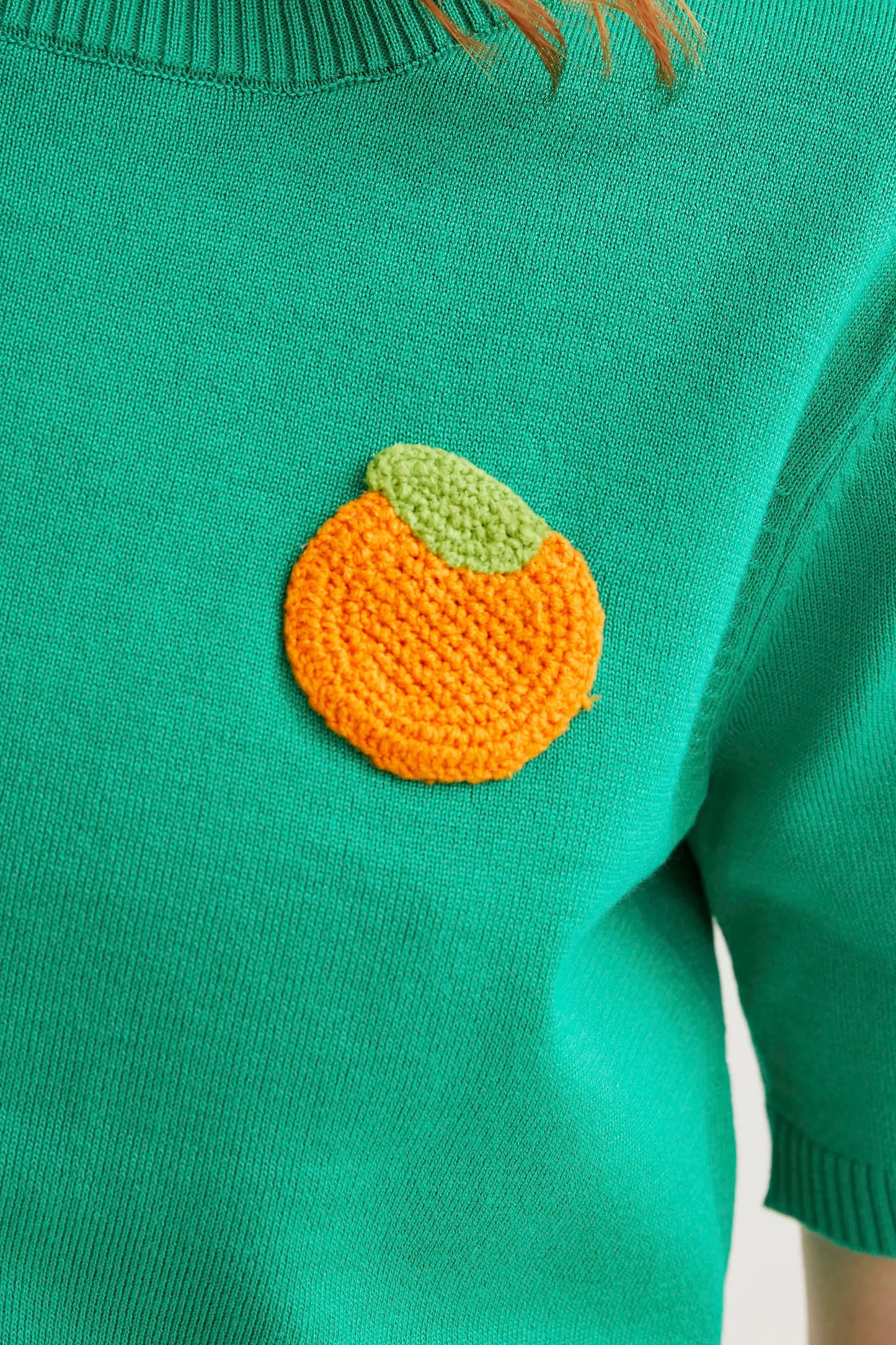 Top in maglia verde con ricamo arancione
