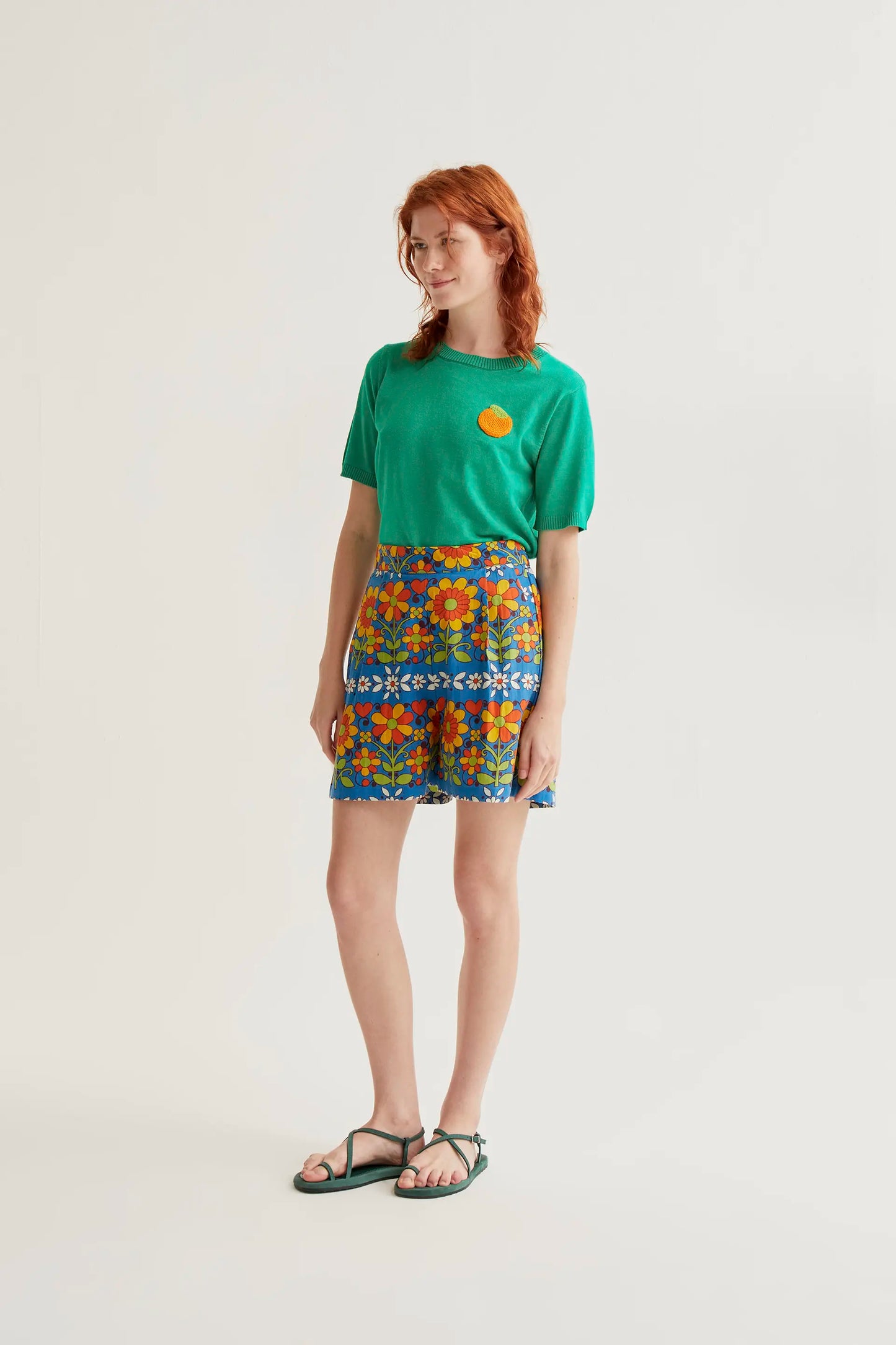Top in maglia verde con ricamo arancione