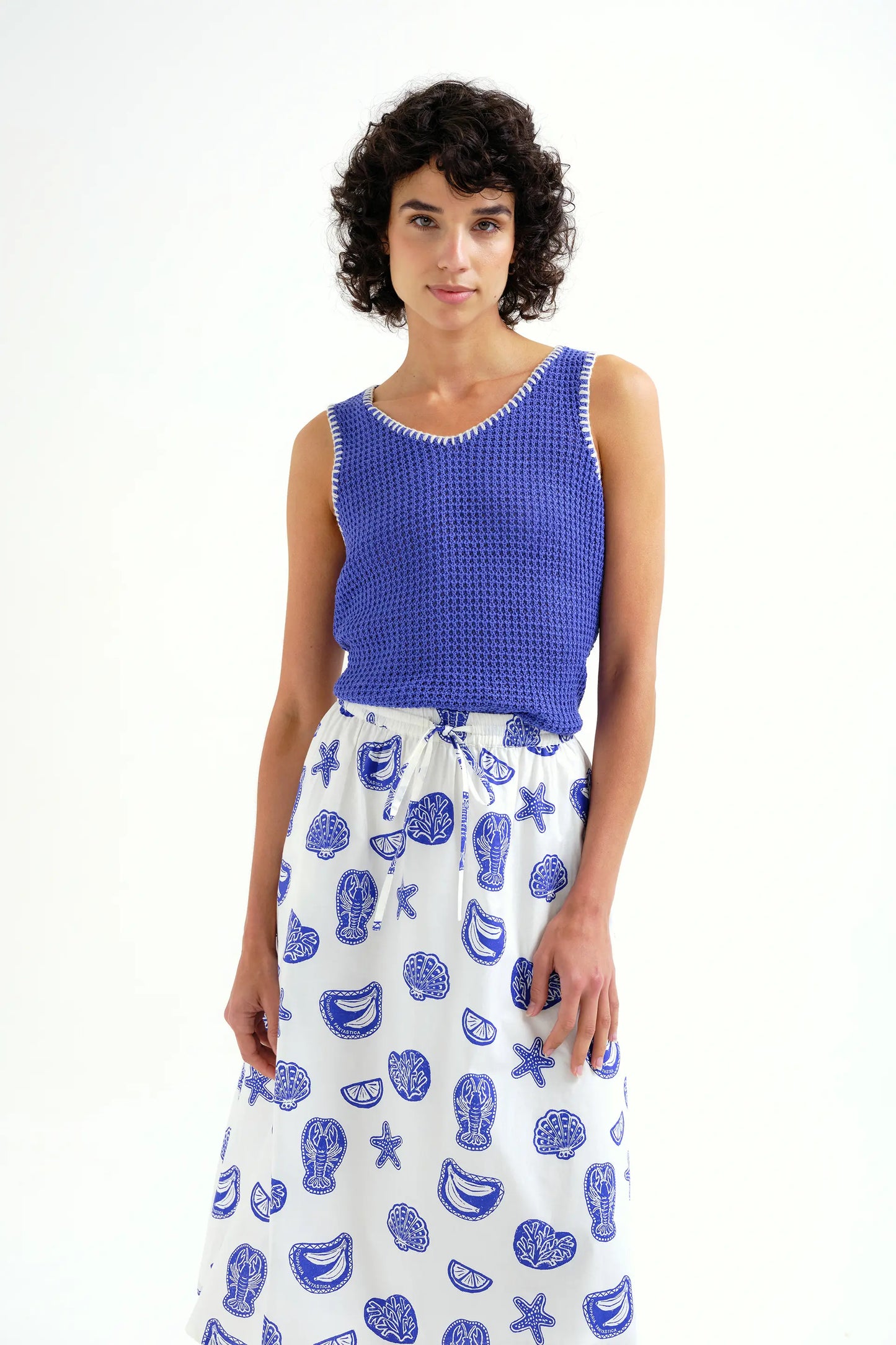 Top in maglia traforata blu con dettagli ricamati bianchi