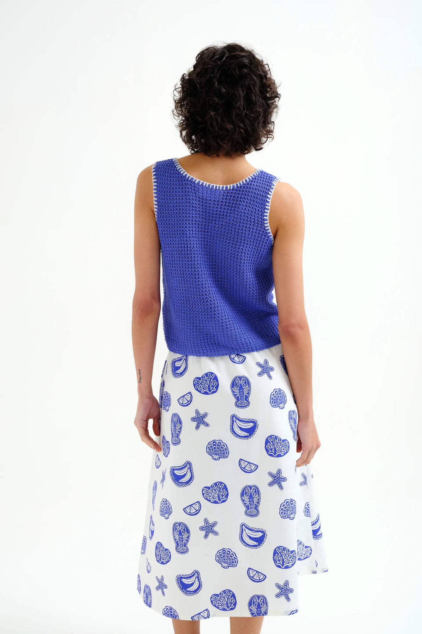 Top in maglia traforata blu con dettagli ricamati bianchi