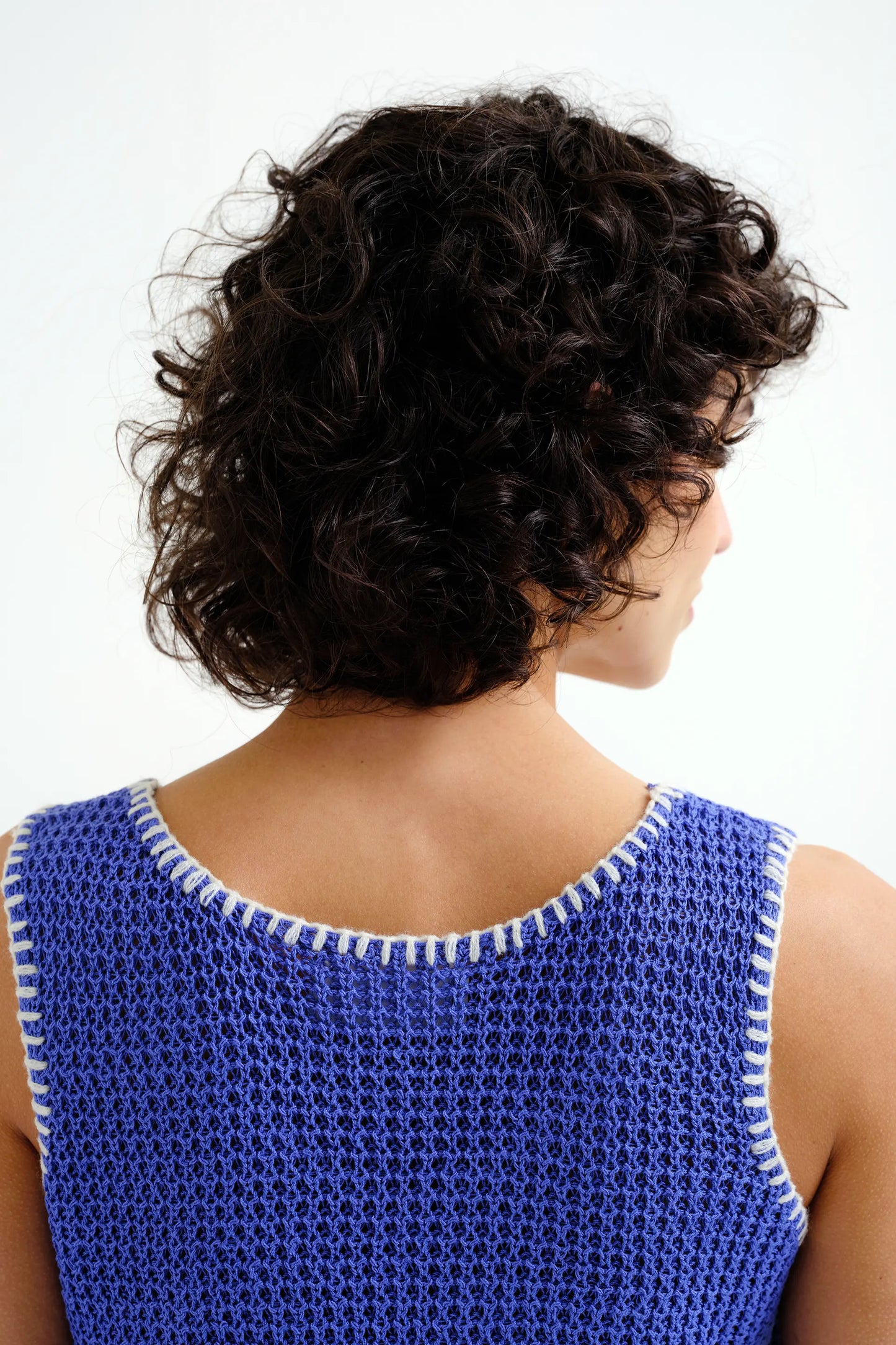Top in maglia traforata blu con dettagli ricamati bianchi