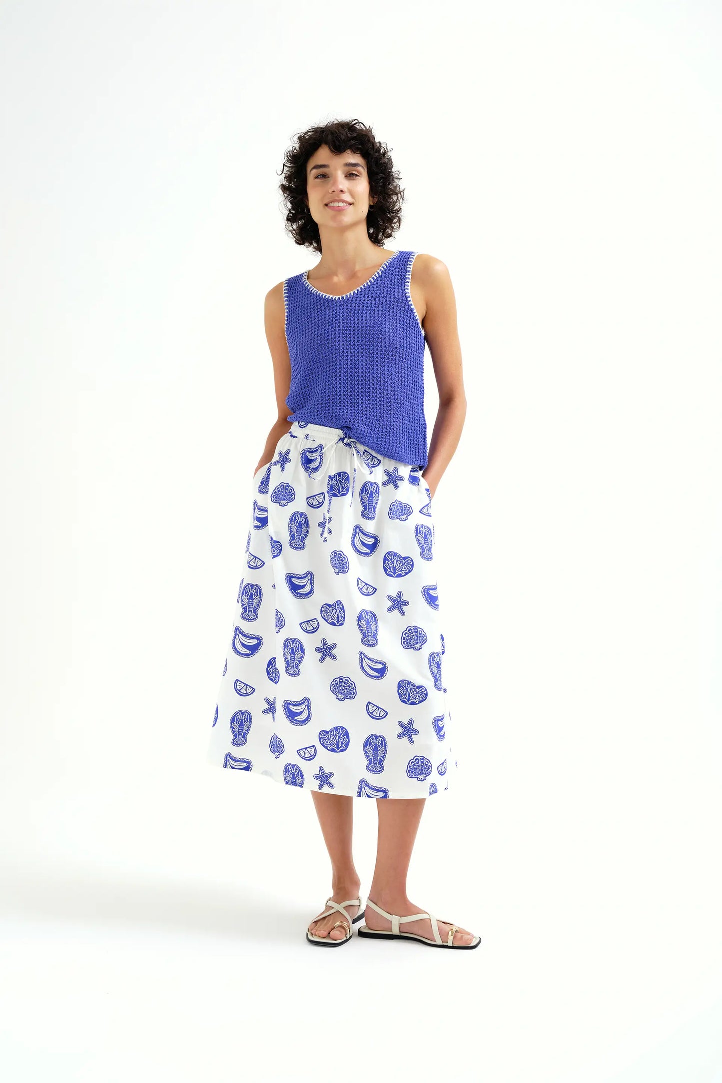 Top in maglia traforata blu con dettagli ricamati bianchi
